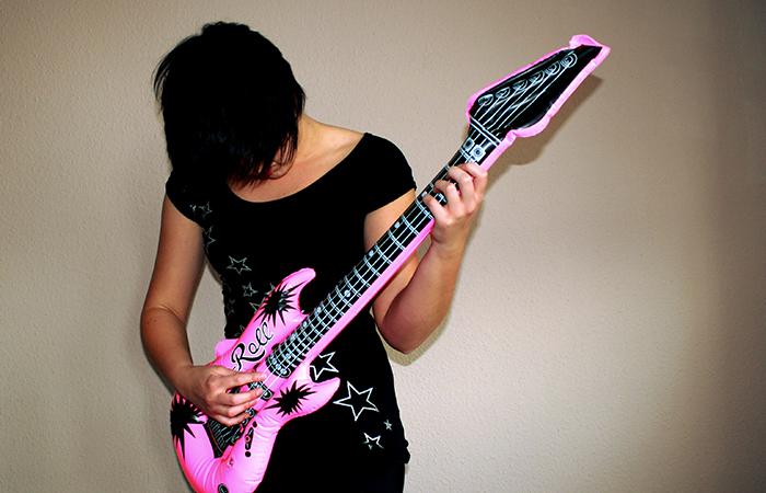woman plays blow up guitar