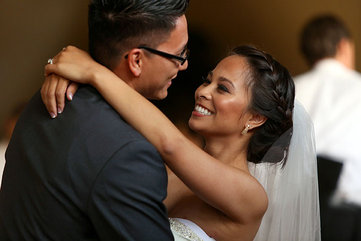 close up of a smiling bride and groom dancing at their wedding reception