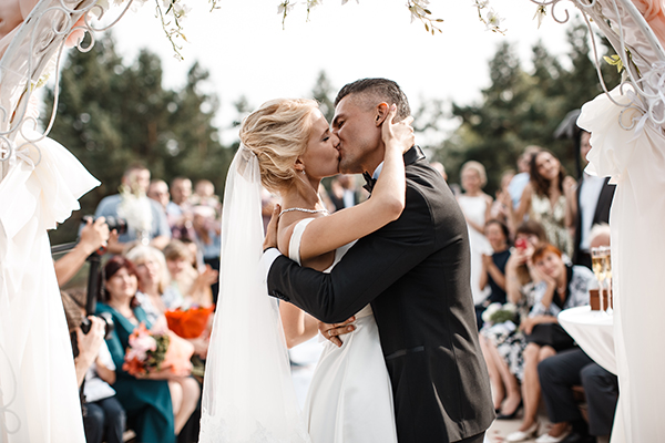 a bride and groom kissing at the alter in front of their wedding guests